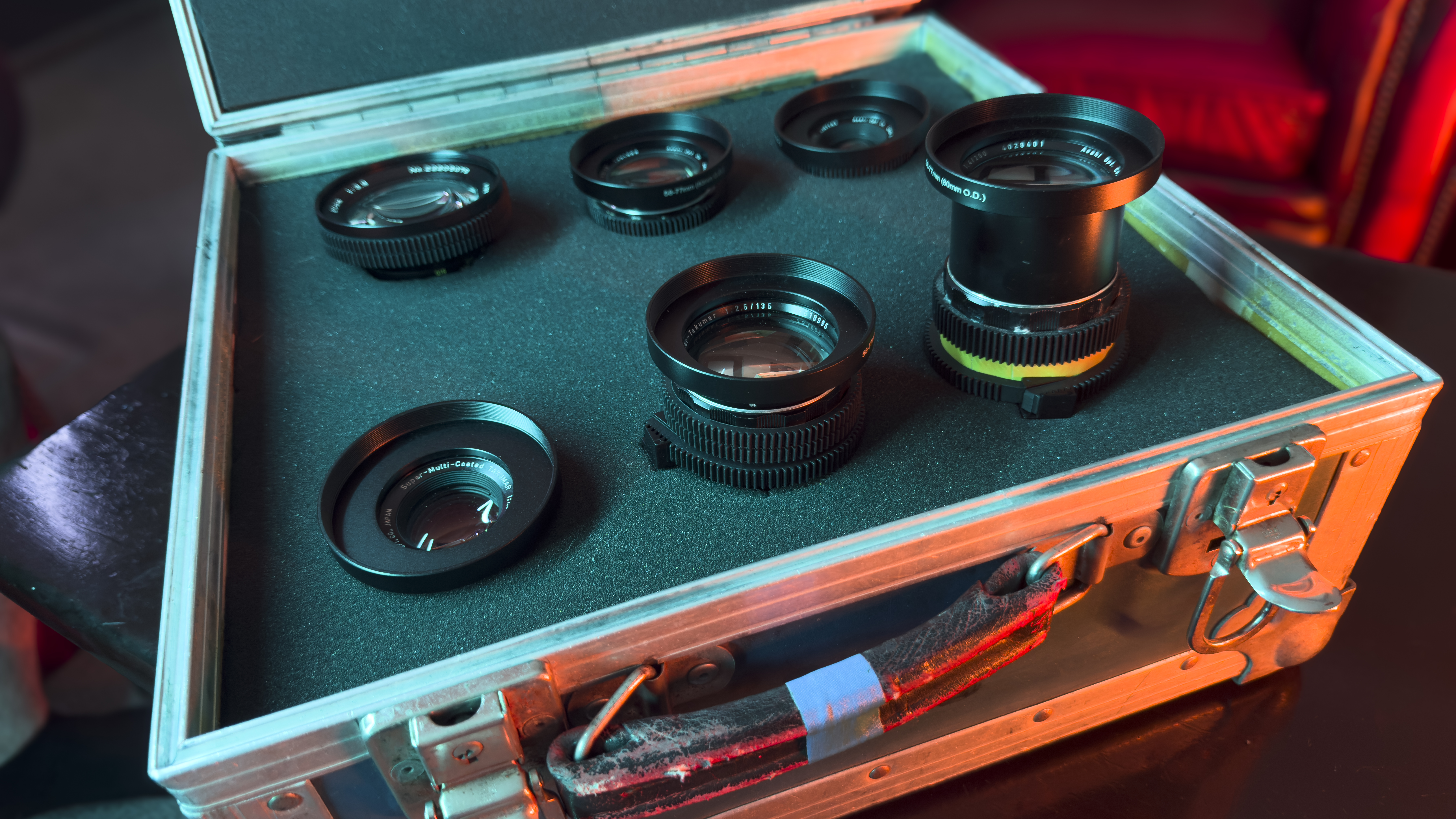 A box full of camera lenses lit by a red light