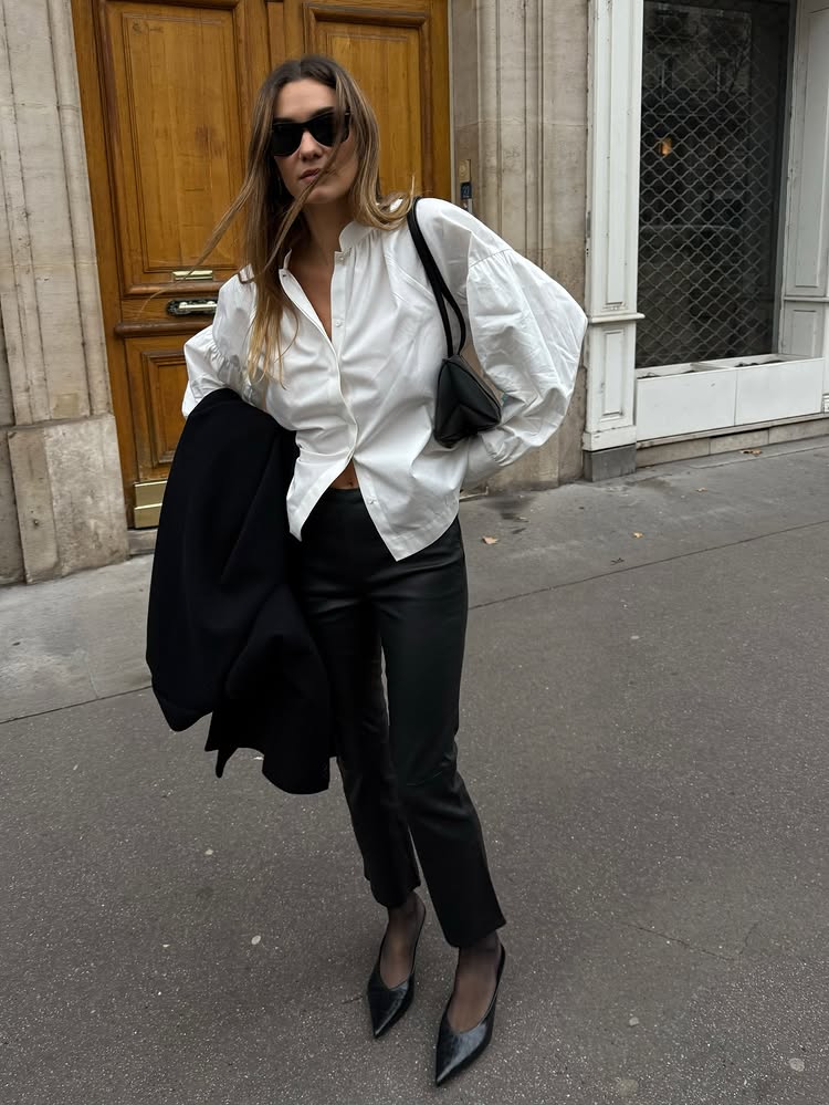An image of @annelauremais wearing leather effect leggings, one of the biggest leggings trends for 2026, with a white blouse and pointed-toe heels.