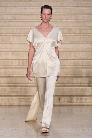 A Tove model walks the spring/summer 2025 runway in silk trousers.