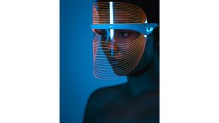 A woman wearing a blue LED light therapy mask