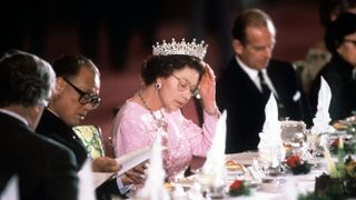 peking, china october 13 the queen adjusting her tiara whilst reading the menu before dinner is served at a banquet held in her honour during her visit with prince philip to peking, china the queen is wearing queen mary's 'girl's of great britain and ireland' tiara photo by tim graham photo library via getty images