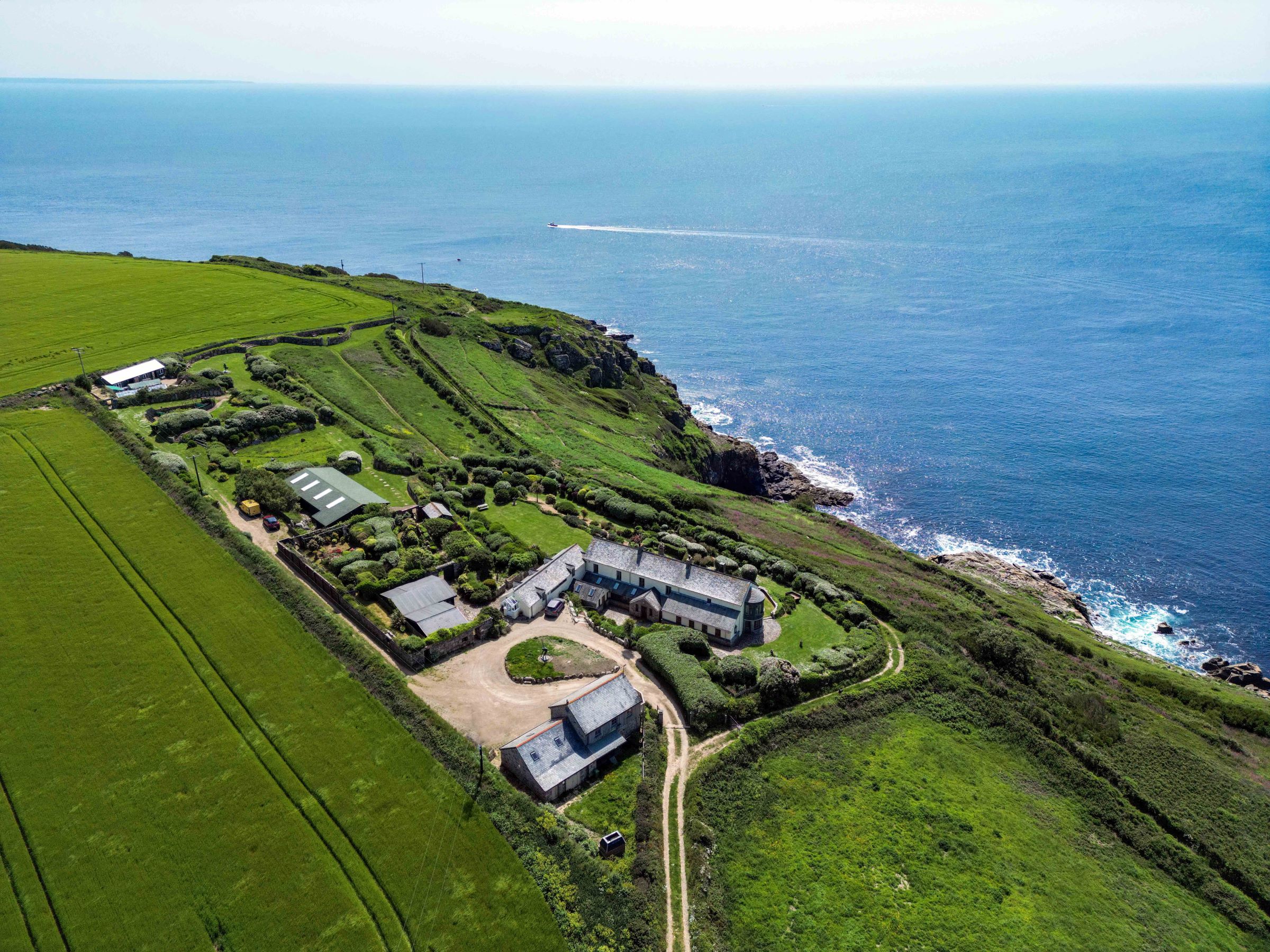 The house sitting on a cliffside with a view over the sea