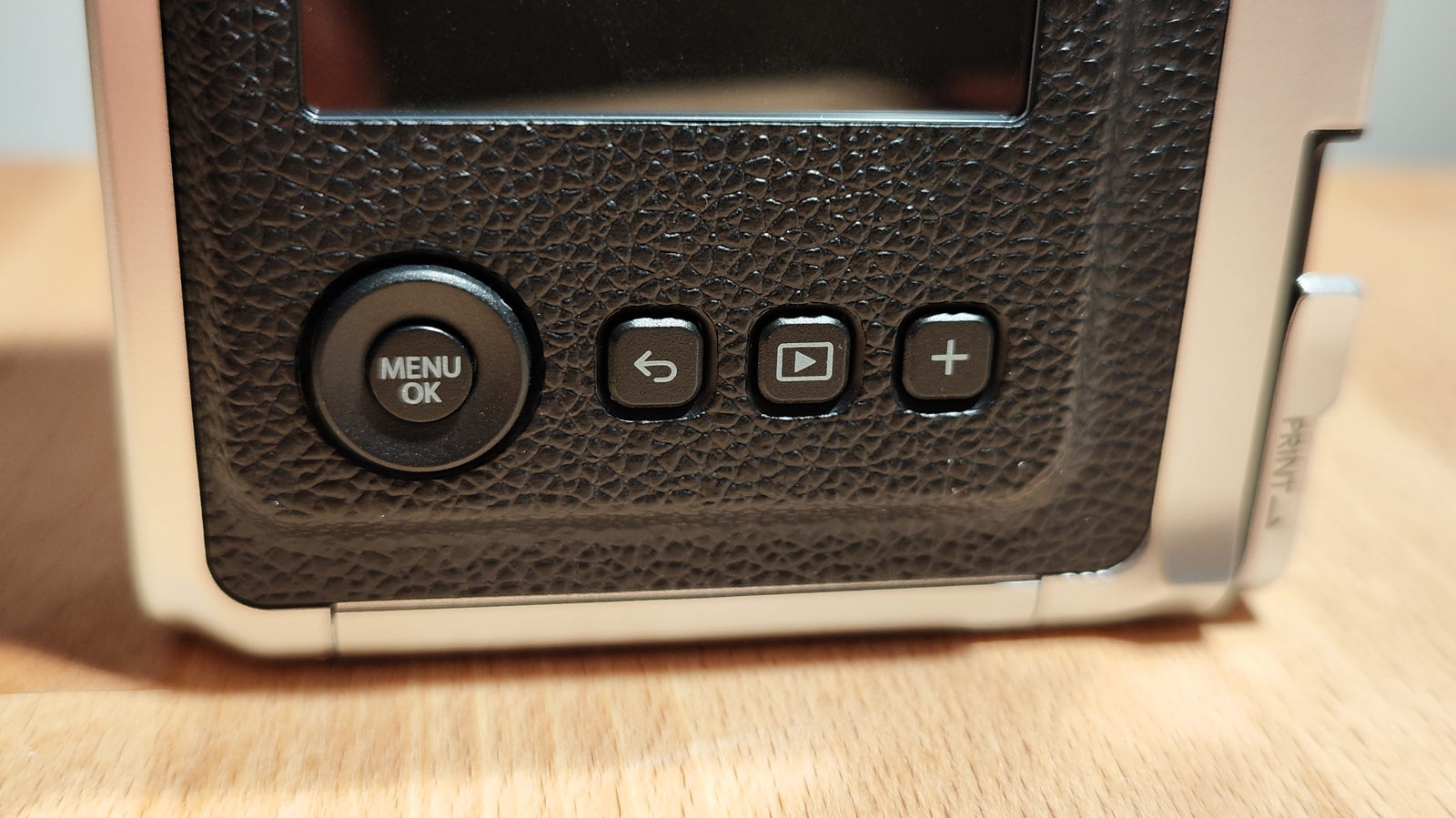 The Fujifilm Instax Mini Evo on a wooden table