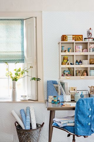 home office decorated with blue subtle wallpaper and decorative items