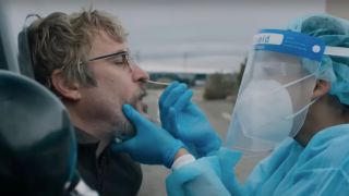 Joaquin Phoenix getting a covid test performed by a masked health worker in Eddington