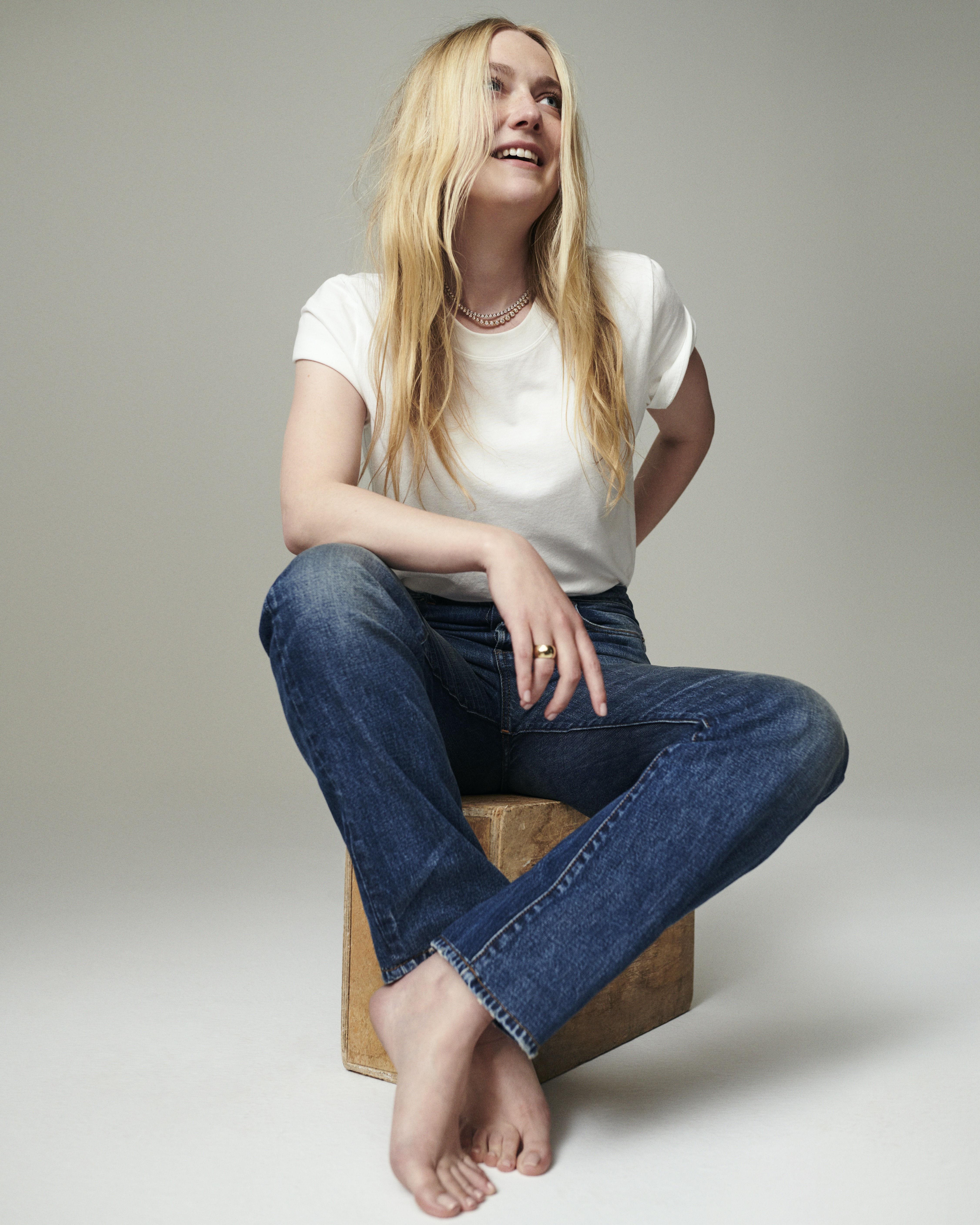 Dakota Fanning for Madewell campaign wearing The Dakota Perfect Crewneck Tee in white and The Dakota Longline Straight Jean with gradient background