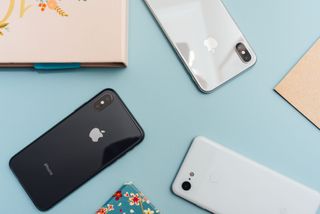 A selection of iPhones laid out in colourful cases