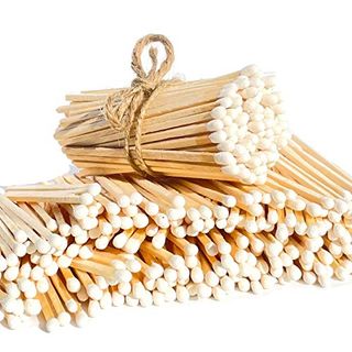 A tied up bindle of white tip matches on top of a stack of untied white tip matches