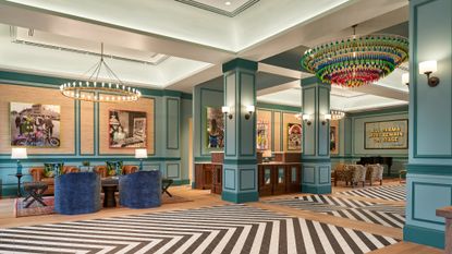 The colorful lobby at The Memphian hotel has two large chandeliers and chevron rugs