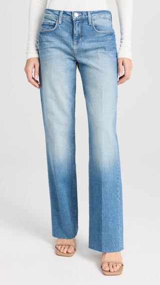 a model wears light-wash, wide-leg blue jeans