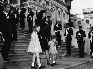 Jackie Kennedy and her children John Jr. and Caroline walk past a guard of honor at the funeral of President Kennedy.