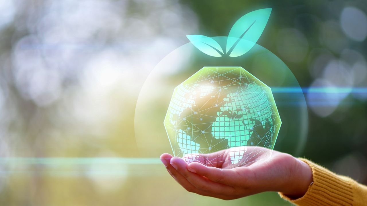 Woman hand holding green holographic Earth.