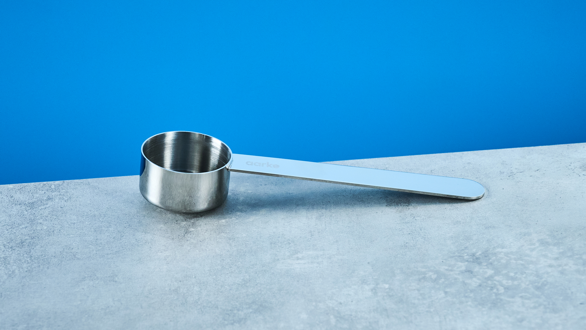 the aarke french press in silver showing the french press filter system, lid, spout, and inside photographed against the blue tom's guide background