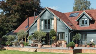 large house with tiled roof and green weatherboard exterior