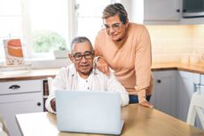 Shot of an elderly couple using a laptop in a kitchen at home - stock photo