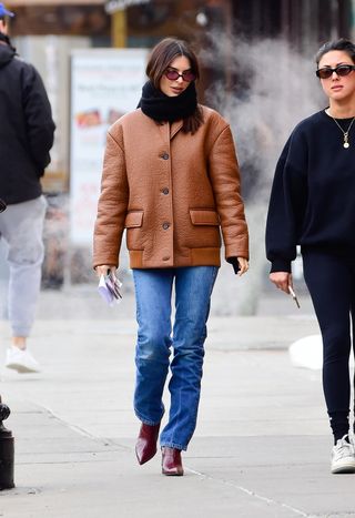 Emily Ratajkowski trägt burgunderrote Stiefel.