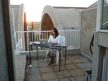 Kari Rae Seekins works on a laptop outside