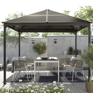 A backyard with a gazebo and an outdoor dining set
