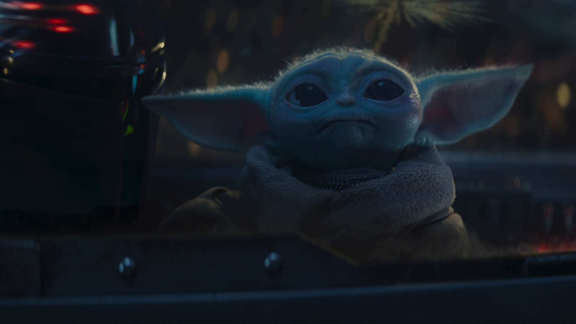 Baby Yoda stares out of a cockpit looking at fireworks in The Mandalorian season 3