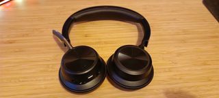 A pair of Poly Voyager Focus 2 headphones on a wooden desk