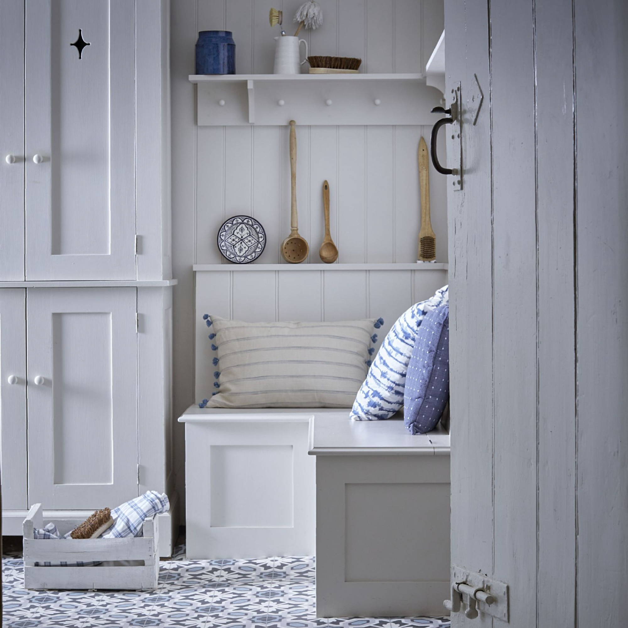 utility room colour ideas, white utility room with blue pattered floor tiles, cabinets and bench seat, peg rail