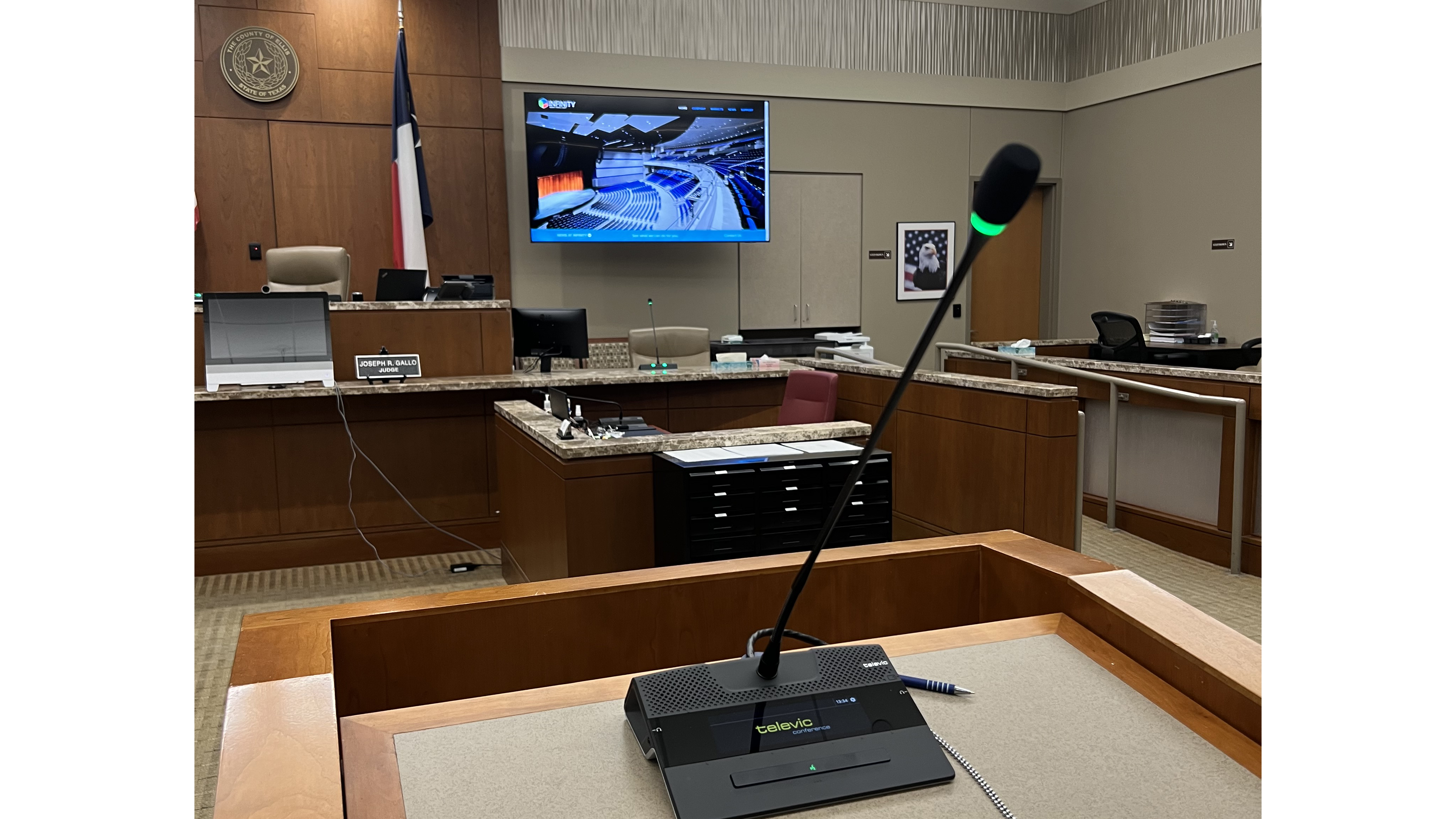The Ellis County Courthouse with a mic standing in front of the judge&#039;s bench. 