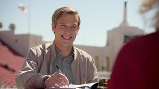 Live From The Other Side medium Tyler Henry signing paper smiling