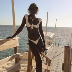amy lefevre standing on a dock wearing a white bikini
