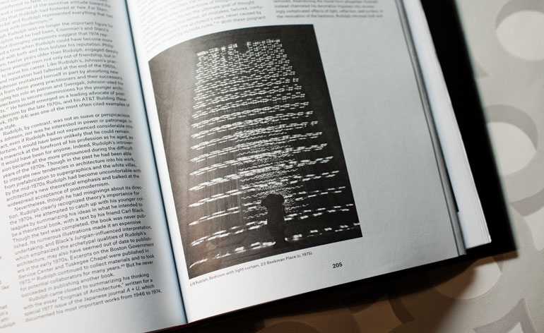 A close-up of a photo in a book which shows a bedroom curtain.
