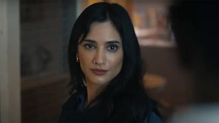 Sasha Bordeaux half-smiling at someone off-camera in Peacemaker season 2