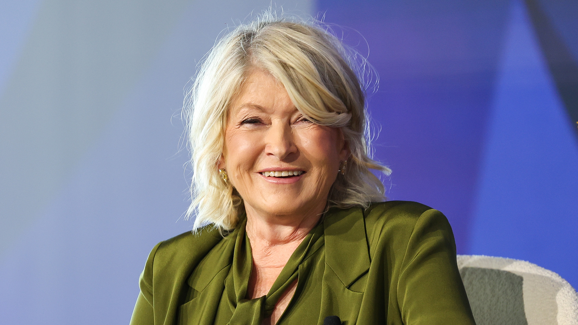Martha Stewart in green against a blue background