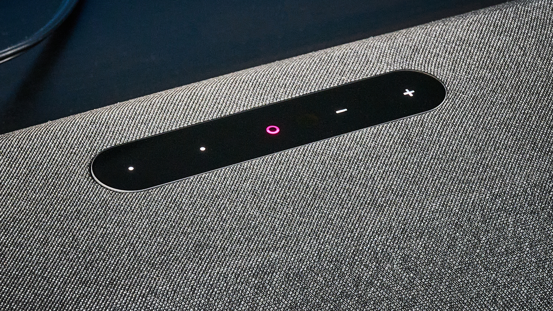 the bluesound pulse cinema soundbar photographed with a TV and the tom's guide blue background
