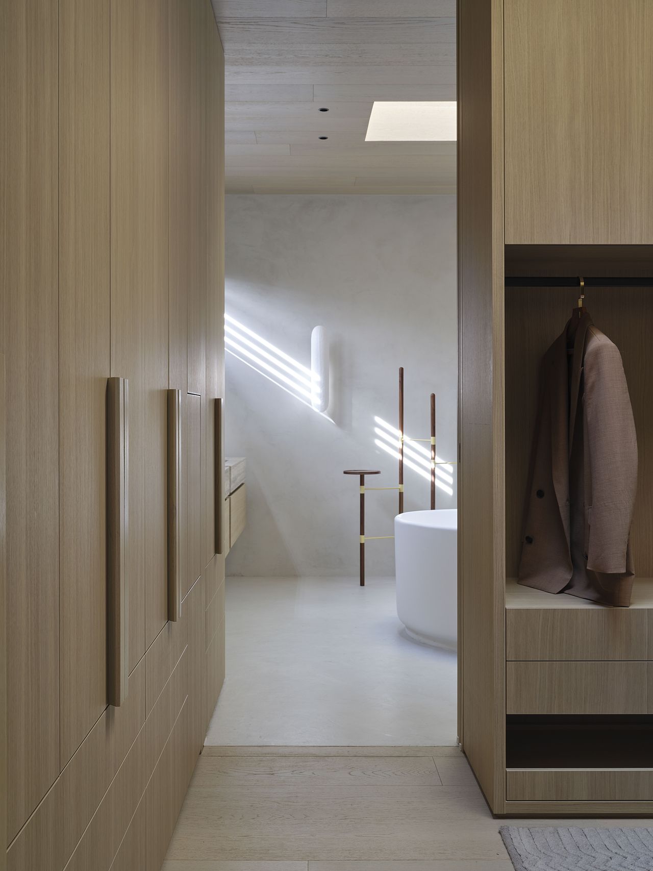 A walk-in wardobe with light wood leads to an ensuite