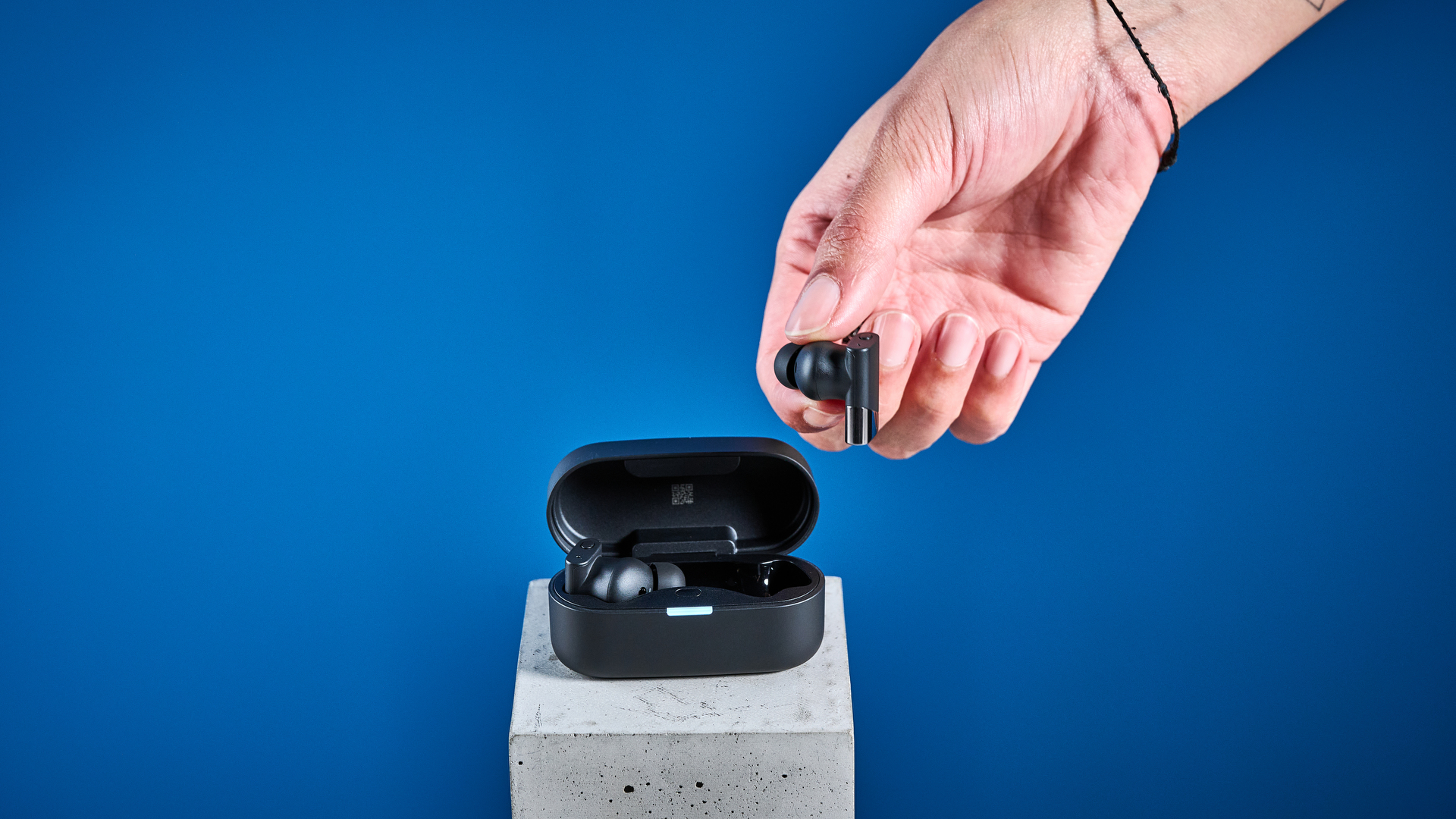 A pair of black Status Pro X wireless earbuds