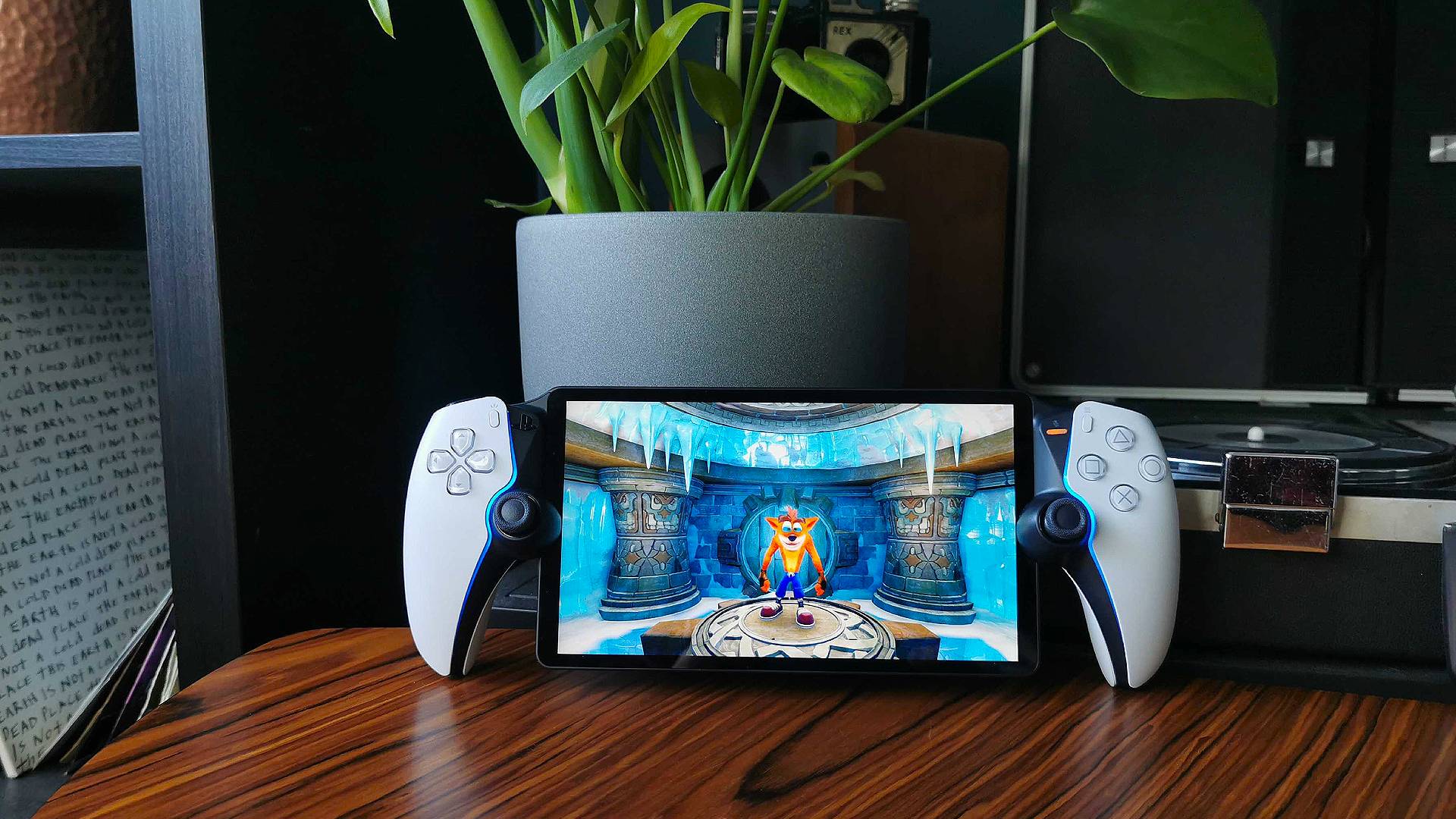 PlayStation Portal on woodgrain table next to plant