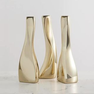 Three sculptural gold candlesticks from Net-A-Porter