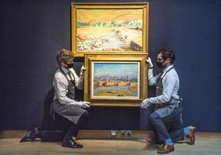 Two men holding a painting