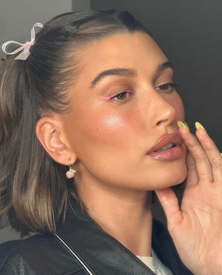 A photo of Hailey Bieber wearing baby pink winged eyeliner