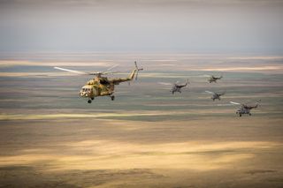 Russian search and rescue helicopters are seen as they fly over Kazakhstan, Tuesday, Sept. 10, 2013, from the city of Karaganda to Zhezkazgan a day ahead of the scheduled landing of the Soyuz TMA-08M spacecraft with Expedition 36 Commander Pavel Vinogrado