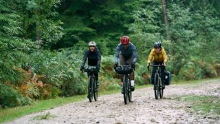 three riders on specialized gravel bikes ride along a fireroad