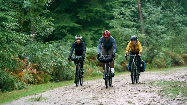 three riders on specialized gravel bikes ride along a fireroad