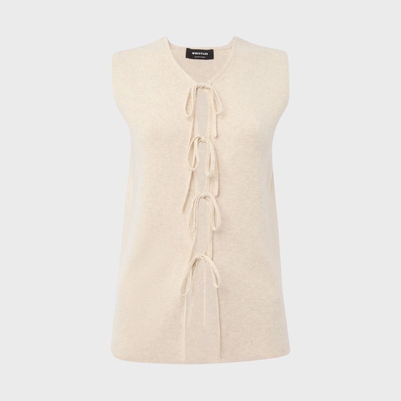 A cutout of a cream tie front waistcoat top