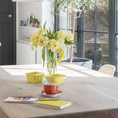 dining table with flower vase and books and tea cup