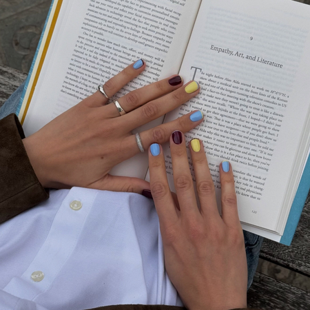 @matejanova reading a book wearing a contrasting french manicure