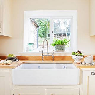 kitchen area with washbasin and white wall