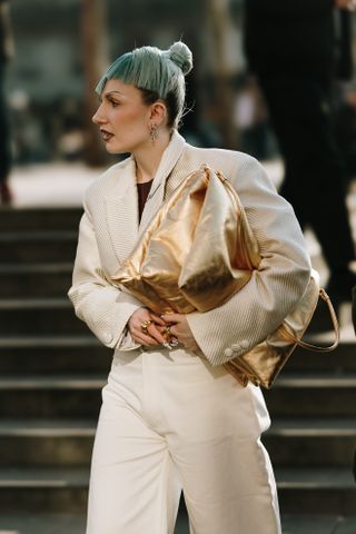 woman in a white suit with short green hair