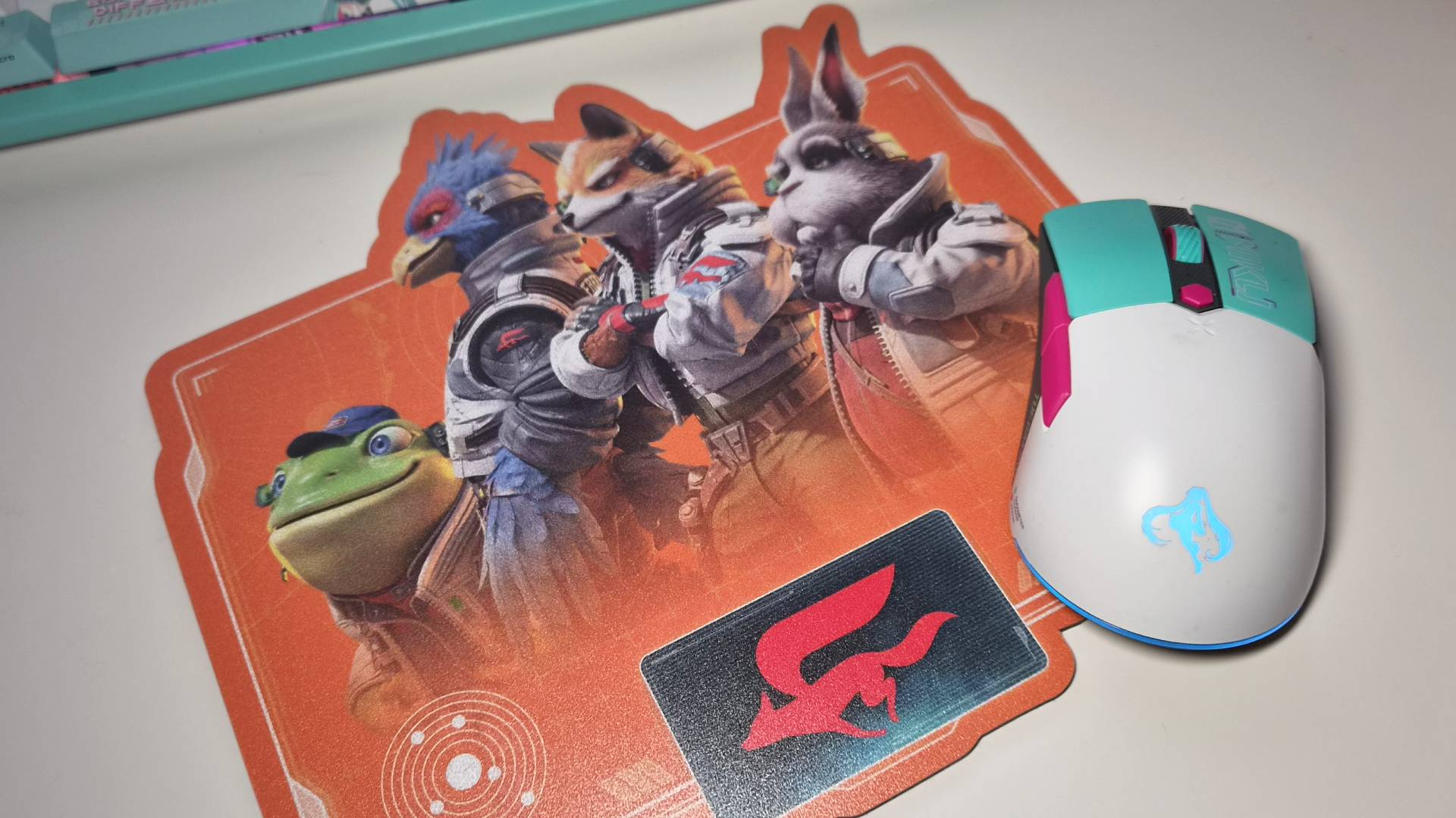 Photo of the Nintendo Star Fox mousepad with a Hatsune Miku mouse sitting on top.