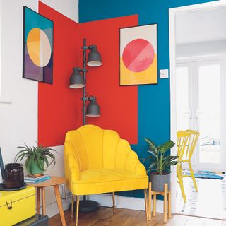 Living room with blue and red block colours on wall with yellow chair.