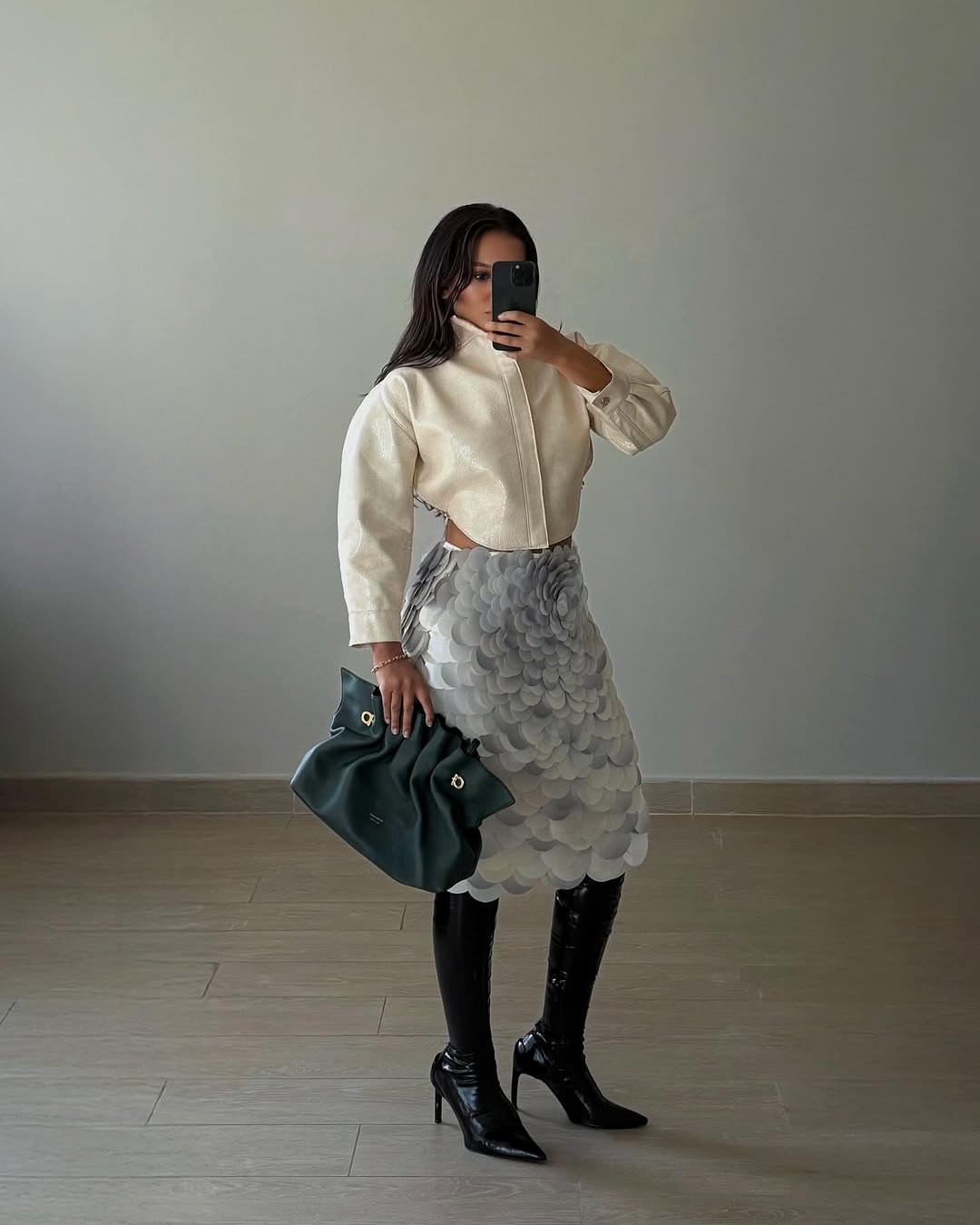 Woman wearing fall boots with skirt outfit 2025.
