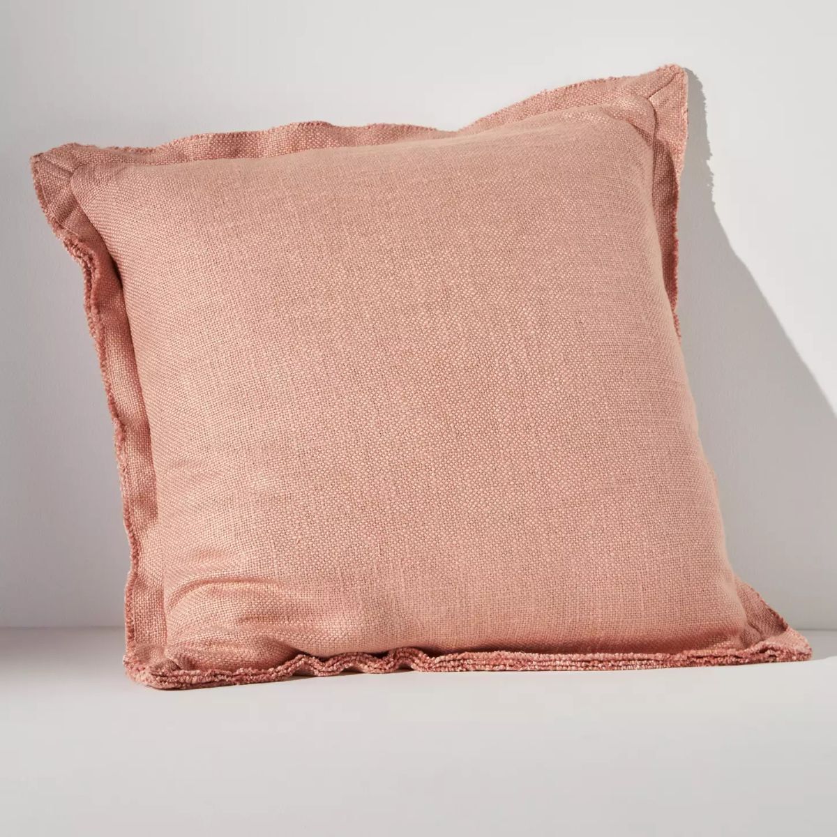 A pink plaster colored linen cushion